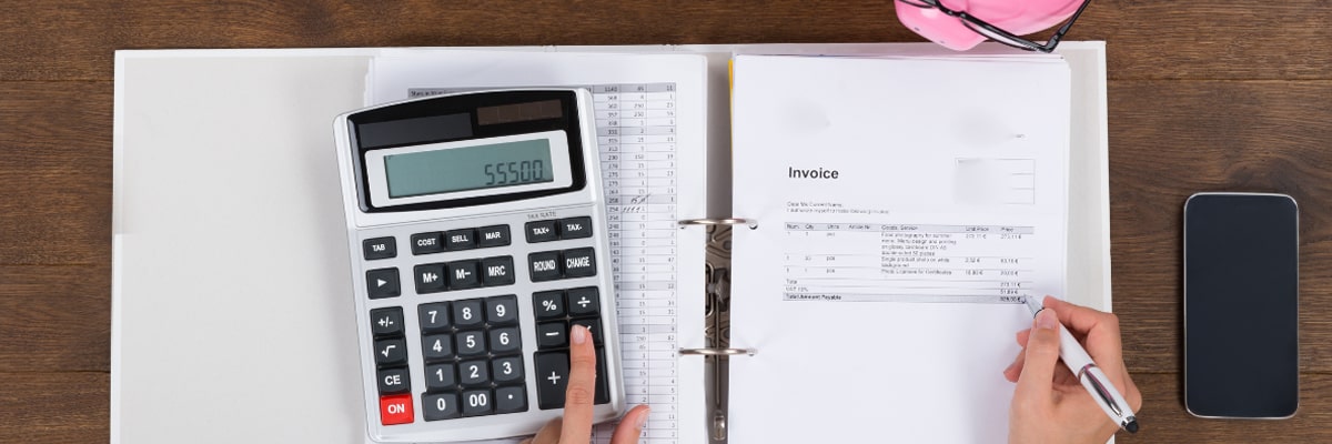 picture of a woman calculating the particulars of an invoice