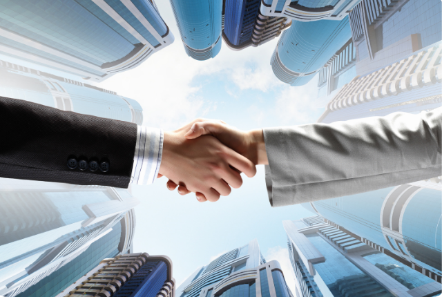 picture showing people people in suits shaking hands after successfully setting up a branch in India